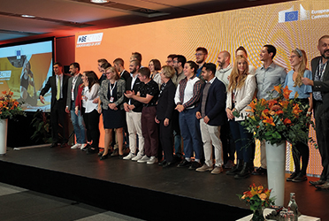 Bild zeigt Menschengruppe auf einer Bühne bei der Veranstaltung (verweist auf: Kongress im Rahmen der tschechi­schen EU-Rats­präsident­schaft: BISp präsentiert zu nach­haltigen Sport­anlagen)